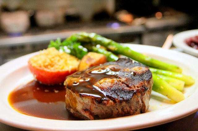Steak so zeleninou a omáčkou naložený na tanieri.jpg